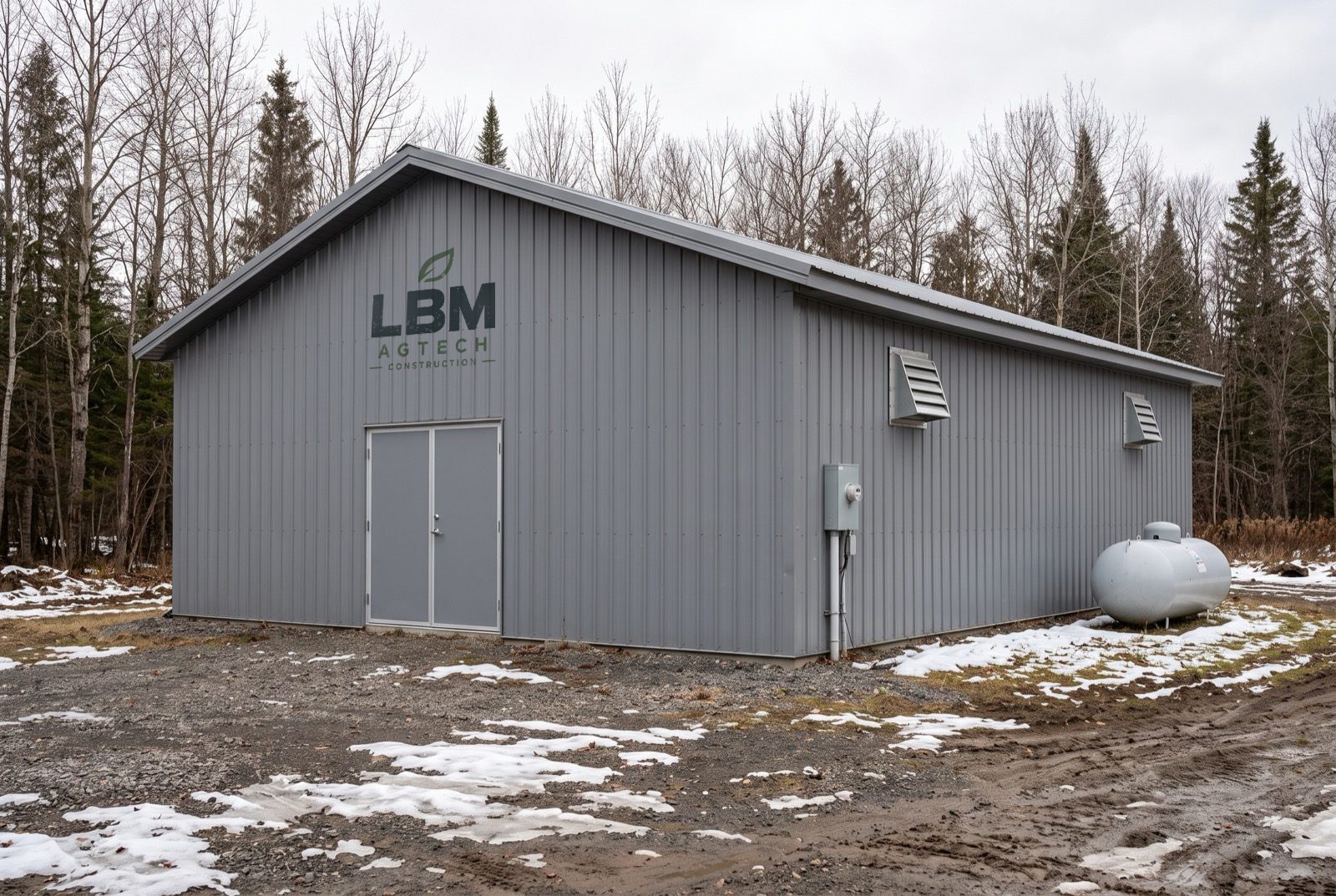 Existing metal building at the edge of a forest, converted into production space