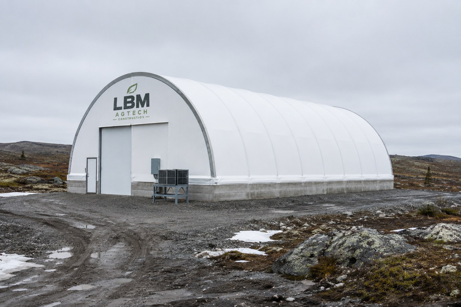 Steel-arch farm dome covered with white fabric, set on a concrete block foundation wall